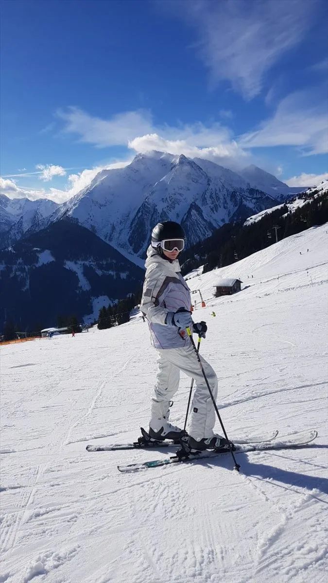 Skier in white on snowy slope