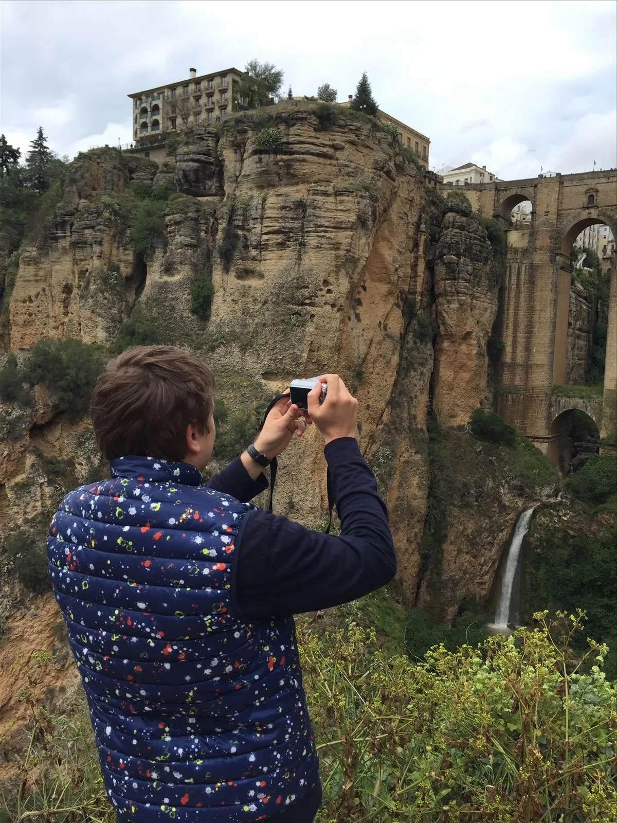 Tourist photographing a bridge in Ronda gorge
