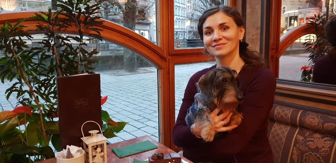Girl with a dog in a café in Karlovy Vary