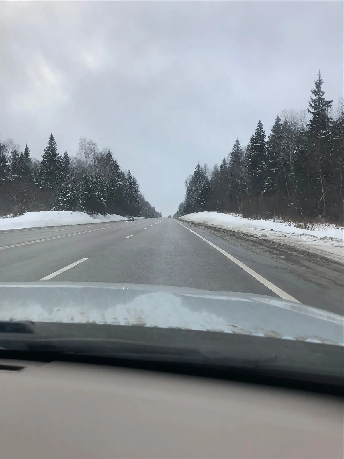 View of snowy highway from the car in winter