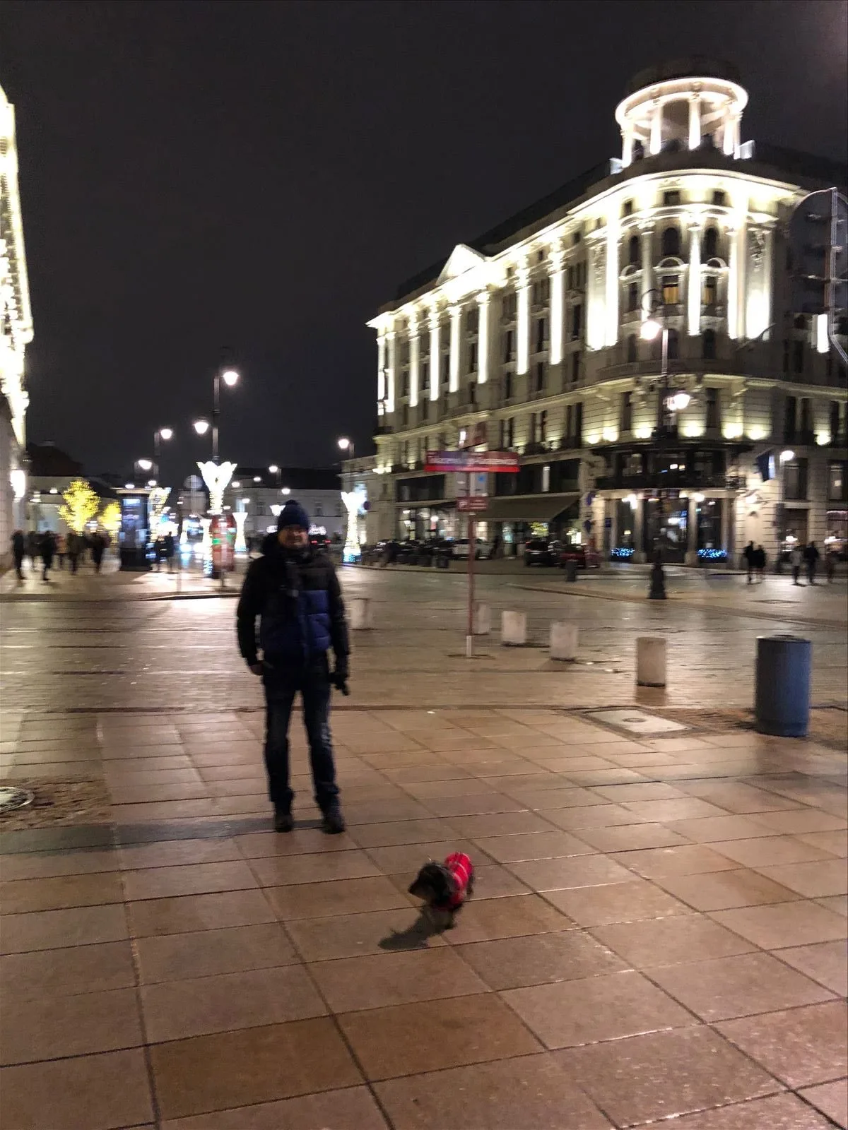 Person on a lit street in Warsaw in winter