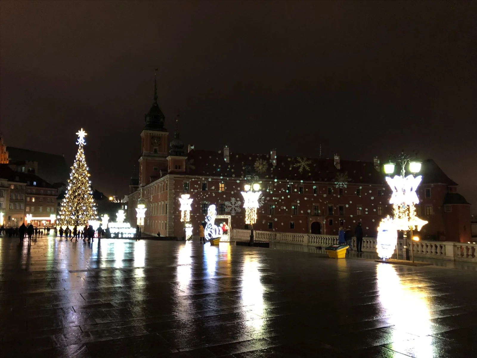Market square in Warsaw with a tree at night