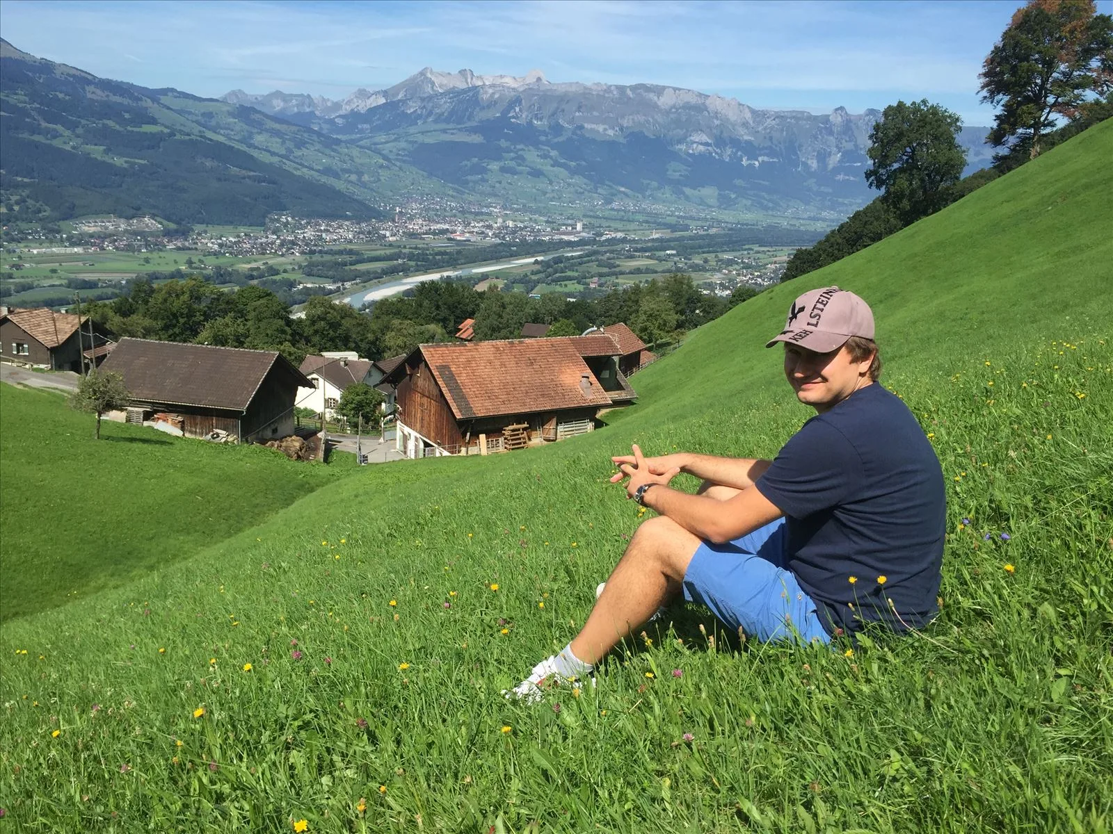 Tourist in an alpine meadow by the mountains