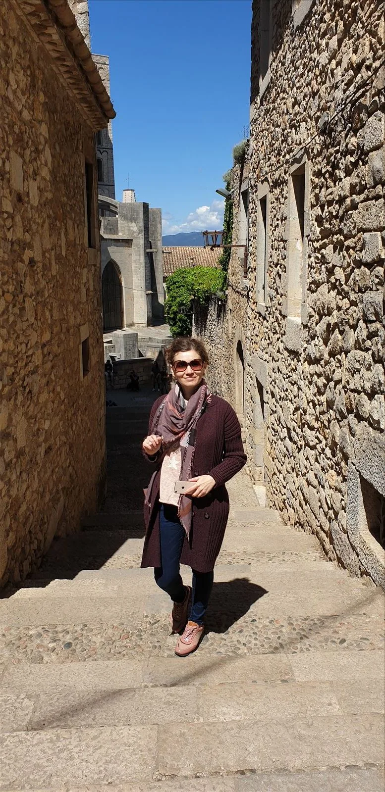 Woman in an alley by a stone wall