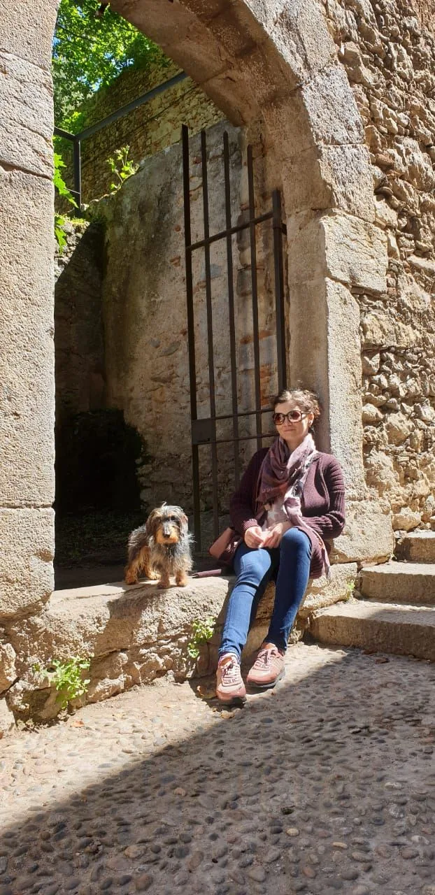 Woman with dog by old wall
