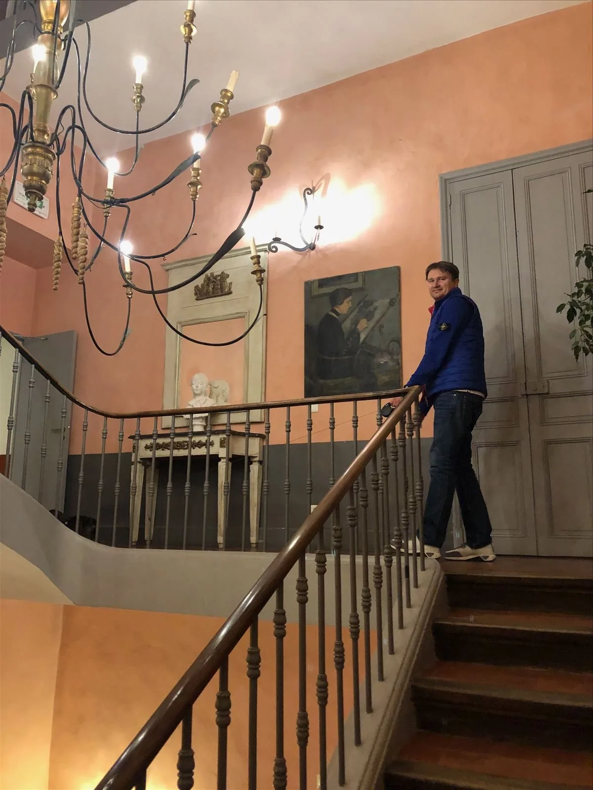 Man on the grand staircase of a château