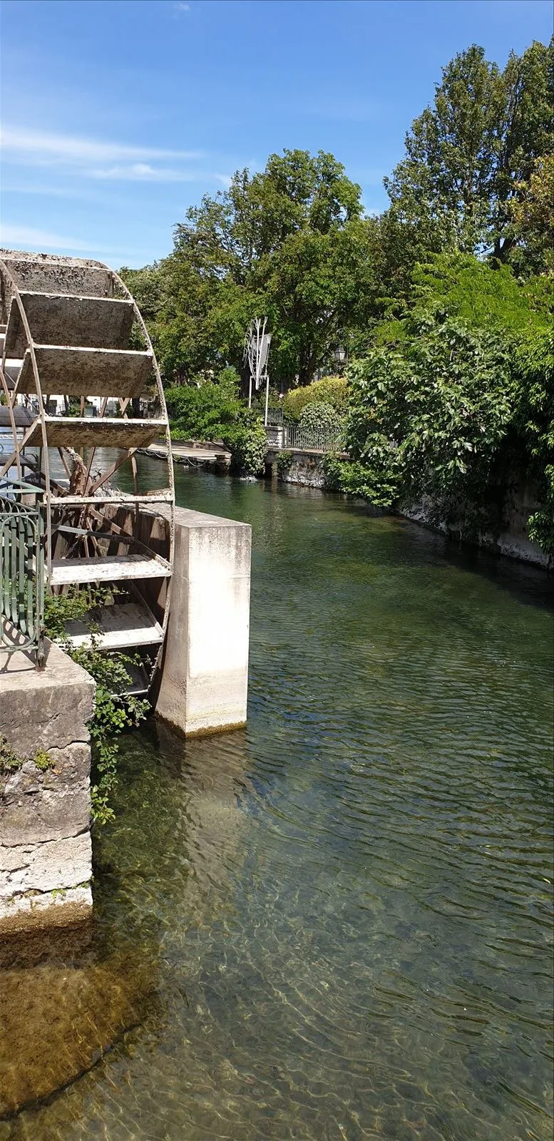 Water wheel in the shade of trees