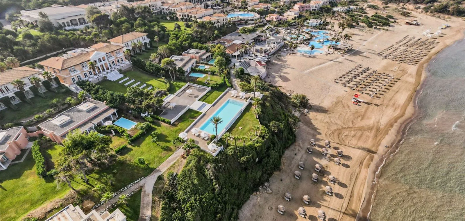 Aerial view of beach and Grecotel hotel buildings