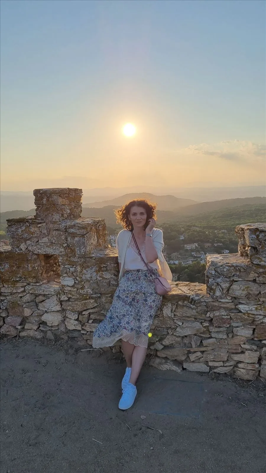 Girl against sunset at Begur Castle