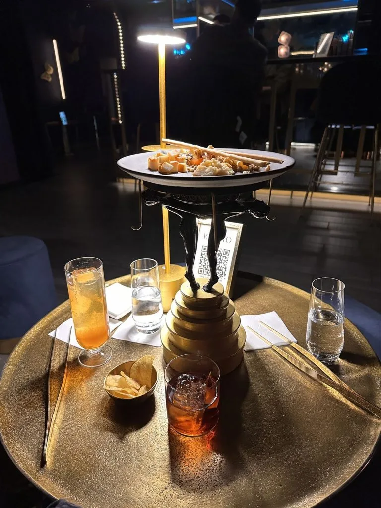 Glass with cocktail and snack at the bar